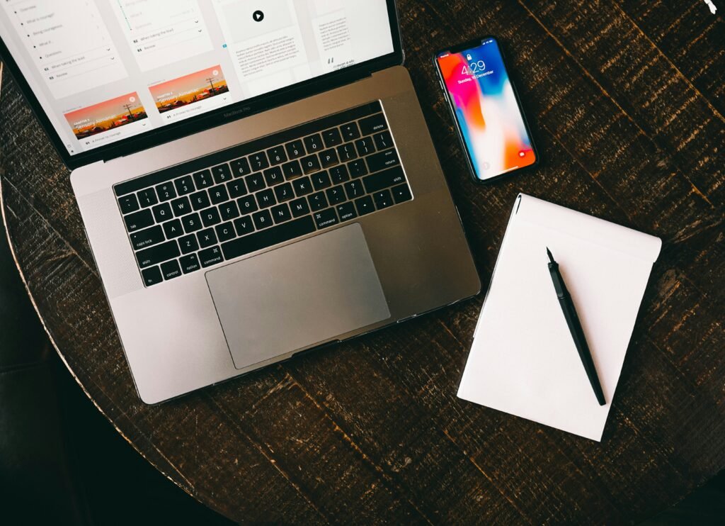 Laptop and handwritten notebook on a desk during college research