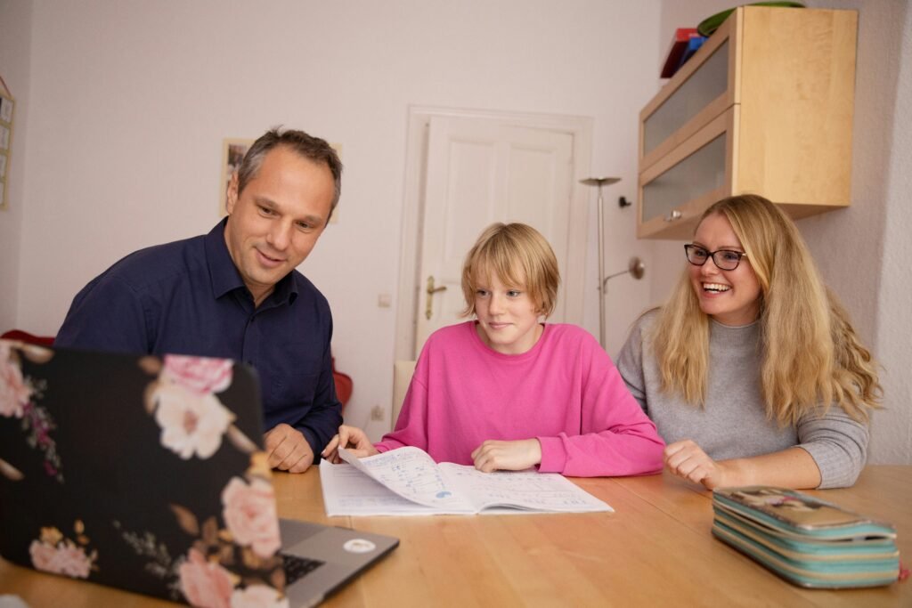 Parent and teenage student talking at a kitchen table with school papers