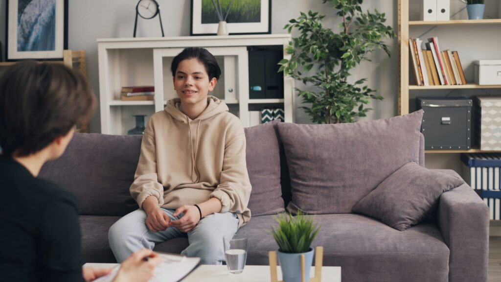 arent and teenage student sitting on a couch having a calm conversation